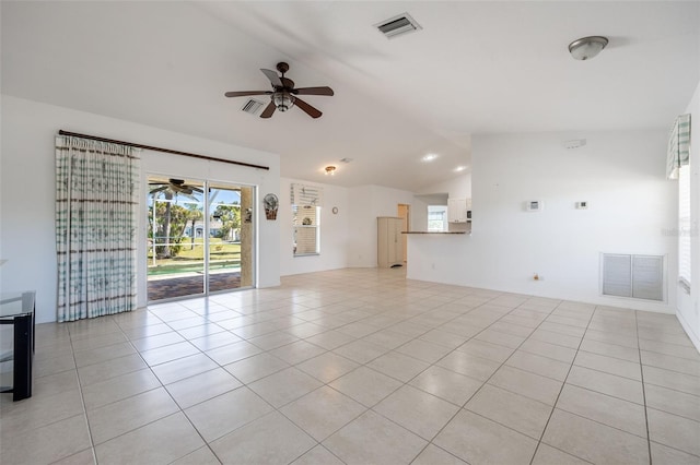 unfurnished living room with light tile patterned floors, visible vents, a ceiling fan, and vaulted ceiling