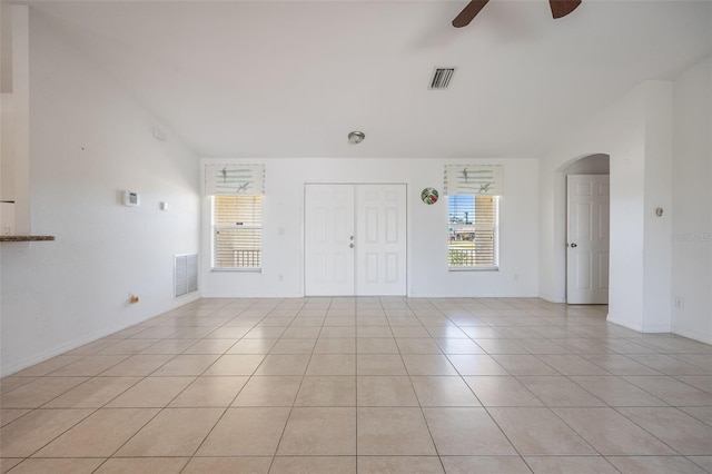 interior space with light tile patterned floors, visible vents, a ceiling fan, and vaulted ceiling