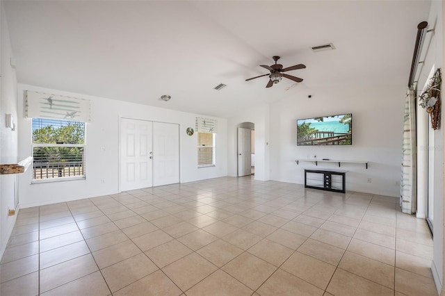 unfurnished living room with visible vents, ceiling fan, lofted ceiling, light tile patterned flooring, and arched walkways