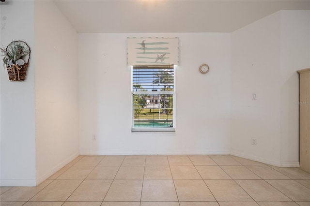 unfurnished room with light tile patterned floors and baseboards