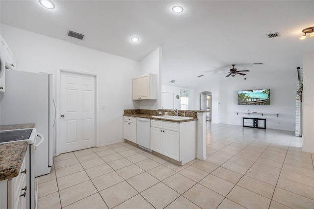 kitchen with white appliances, visible vents, lofted ceiling, arched walkways, and a sink