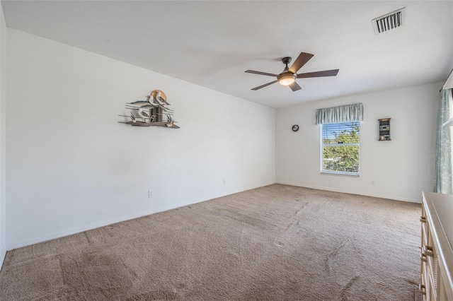 unfurnished room with visible vents, ceiling fan, baseboards, and carpet