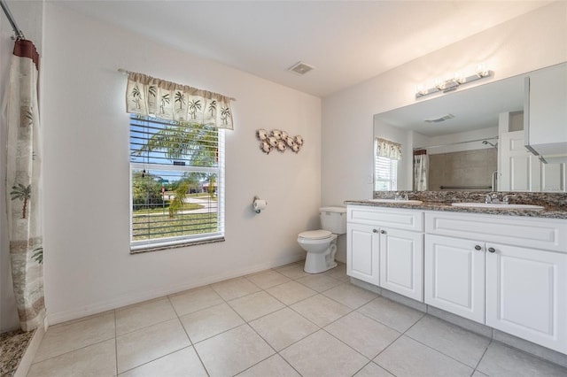 full bathroom featuring visible vents, double vanity, a stall shower, a sink, and toilet