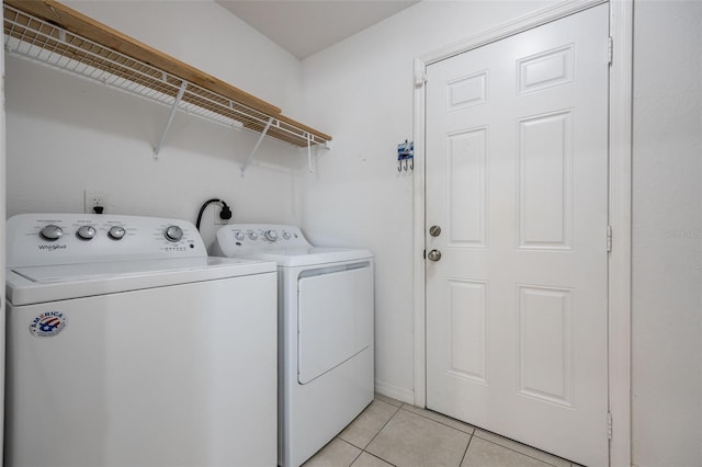 clothes washing area with laundry area, light tile patterned flooring, and washing machine and dryer