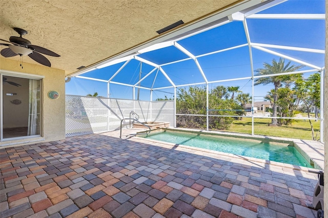 outdoor pool with glass enclosure, a patio, and ceiling fan