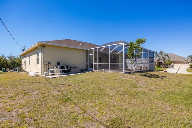 rear view of house featuring a lanai, stucco siding, and a yard