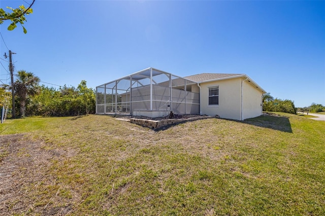 back of house featuring glass enclosure, a lawn, and stucco siding