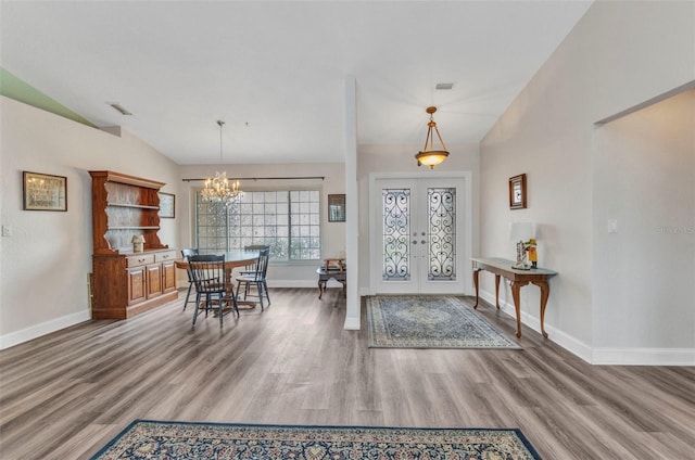 entryway with french doors, wood finished floors, and vaulted ceiling