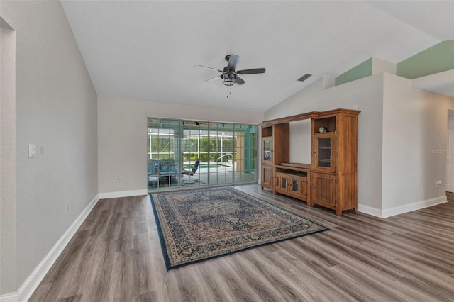 unfurnished living room featuring a ceiling fan, wood finished floors, visible vents, baseboards, and vaulted ceiling