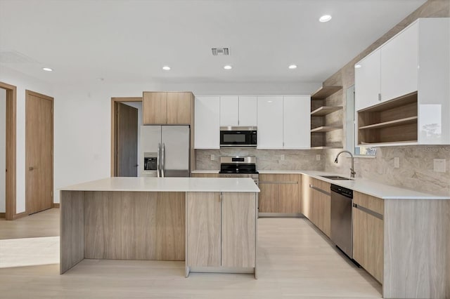 kitchen with visible vents, a kitchen island, open shelves, a sink, and appliances with stainless steel finishes