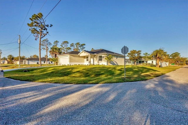 view of front of property featuring an attached garage, driveway, and a front yard