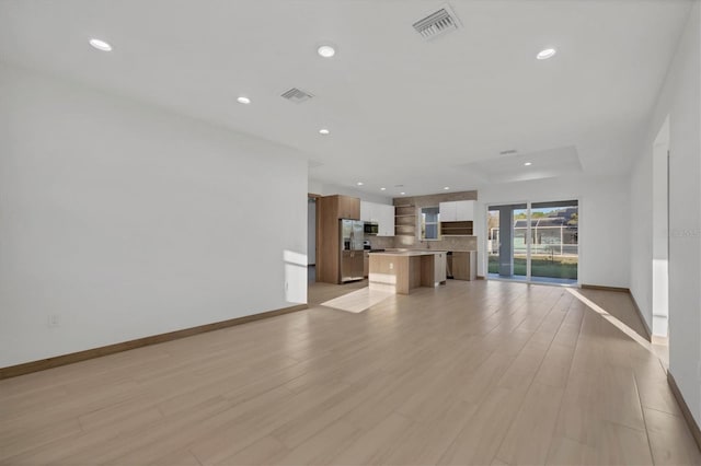 unfurnished living room with recessed lighting, light wood-style floors, and visible vents