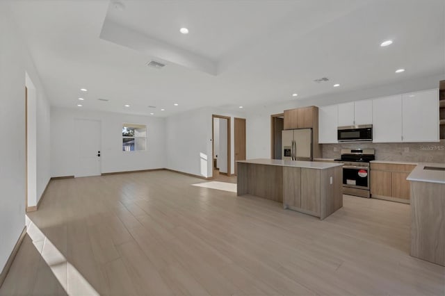 kitchen with visible vents, a center island, light wood-style flooring, appliances with stainless steel finishes, and modern cabinets