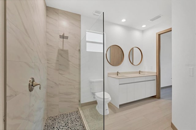 full bathroom featuring a sink, visible vents, walk in shower, and double vanity