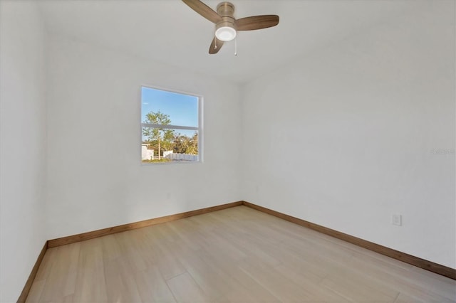 unfurnished room featuring ceiling fan, light wood-style floors, and baseboards