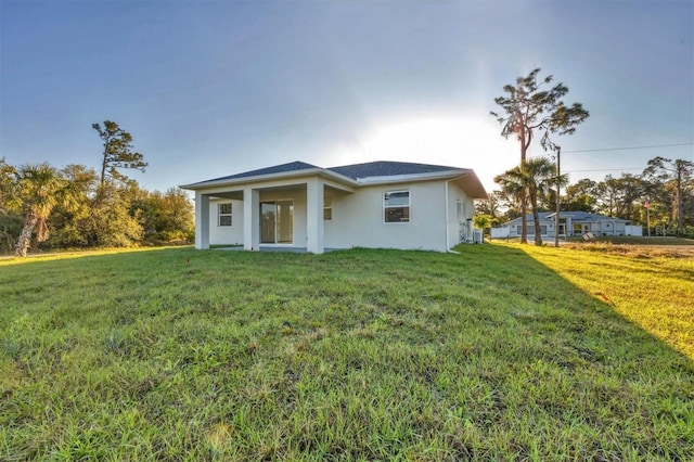 view of front of house with stucco siding and a front yard