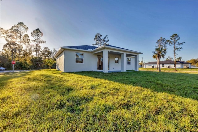 view of front of home featuring a front yard and stucco siding