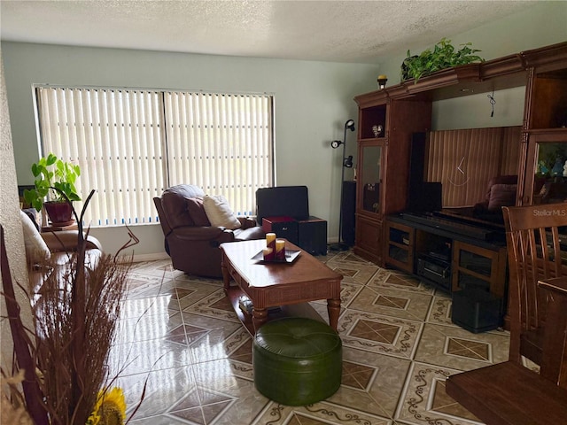 tiled living area with baseboards and a textured ceiling