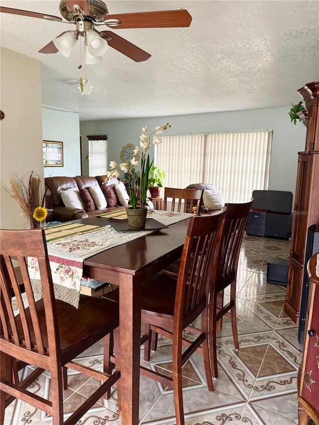 dining room featuring light tile patterned floors, a textured ceiling, and a ceiling fan