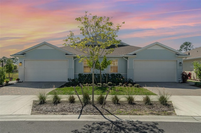 ranch-style house featuring decorative driveway and an attached garage