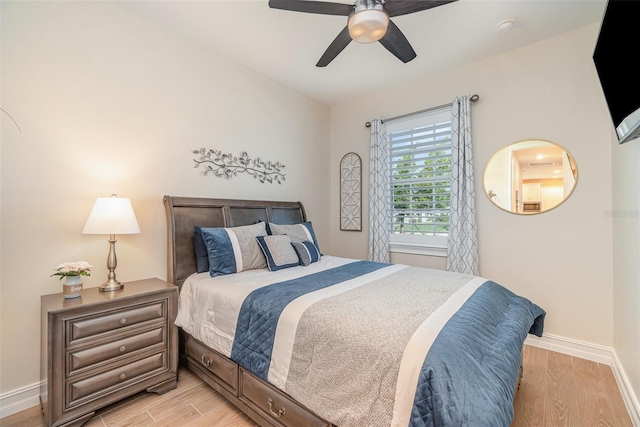 bedroom with baseboards, light wood finished floors, and ceiling fan