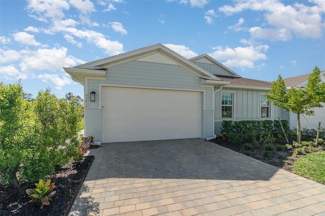 view of front facade featuring decorative driveway, a garage, and board and batten siding