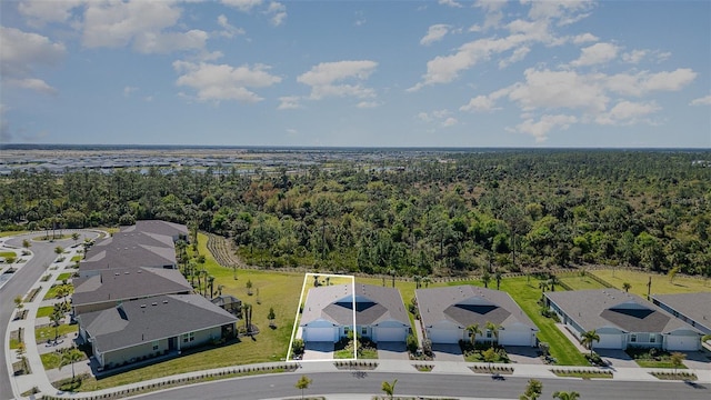 drone / aerial view with a wooded view and a residential view