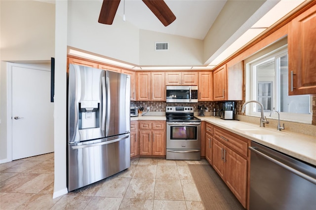 kitchen featuring visible vents, a sink, stainless steel appliances, light countertops, and tasteful backsplash