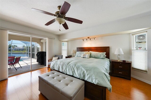 bedroom with light wood-style flooring, access to outside, a sunroom, baseboards, and ceiling fan