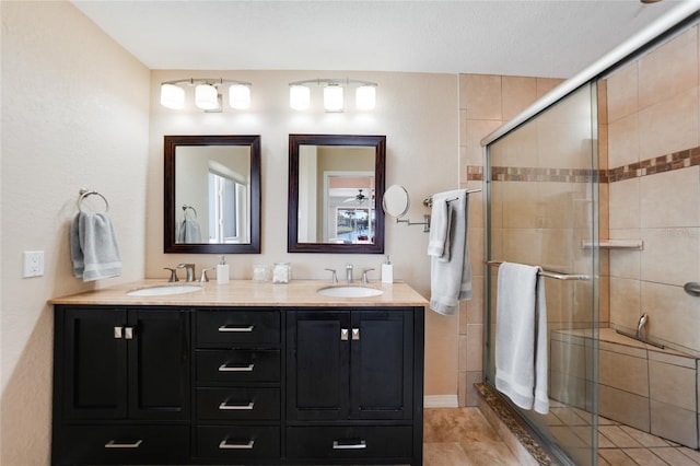 bathroom with double vanity, a stall shower, and a sink