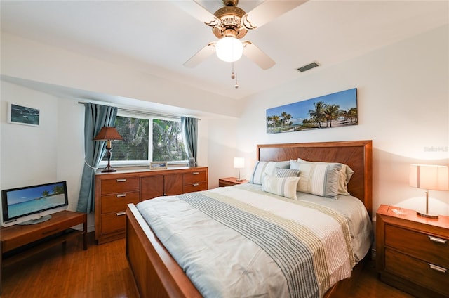 bedroom featuring ceiling fan, visible vents, and dark wood finished floors