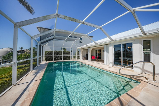 outdoor pool featuring glass enclosure and a patio