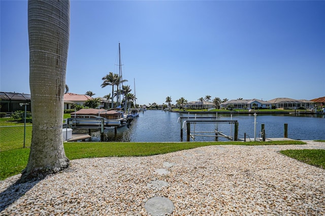 dock area featuring boat lift, a residential view, and a water view