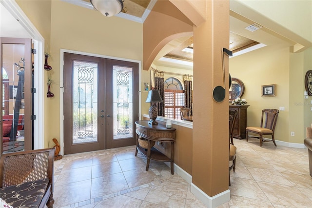 foyer with visible vents, french doors, baseboards, and ornamental molding