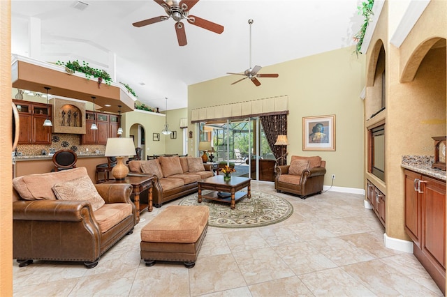 living area featuring visible vents, baseboards, high vaulted ceiling, and ceiling fan