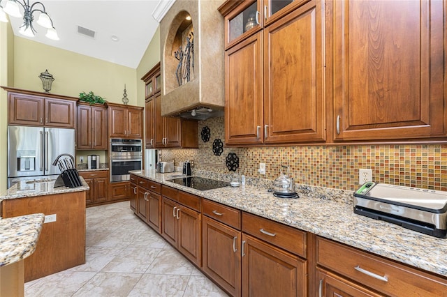 kitchen featuring tasteful backsplash, visible vents, custom range hood, light stone counters, and stainless steel appliances