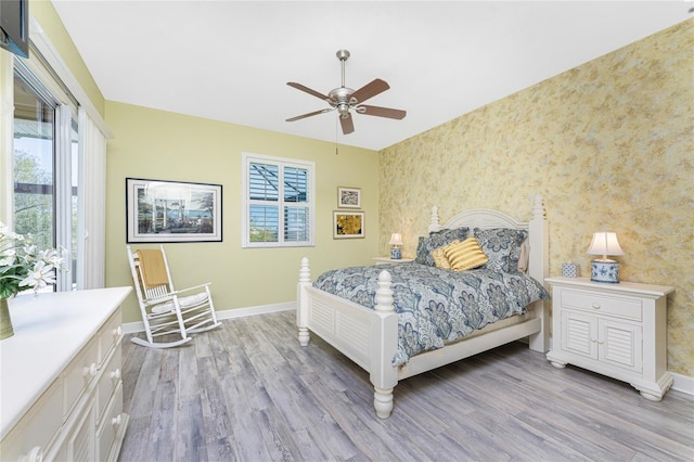 bedroom with baseboards, multiple windows, and light wood finished floors