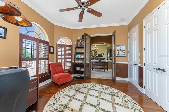 sitting room with visible vents, ornamental molding, a ceiling fan, wood finished floors, and arched walkways