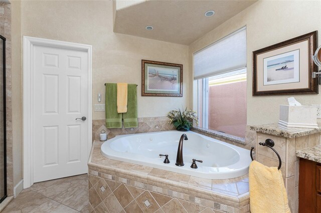 bathroom featuring a shower stall, vanity, and a whirlpool tub