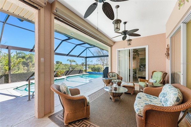 sunroom with a healthy amount of sunlight, a pool, and a ceiling fan