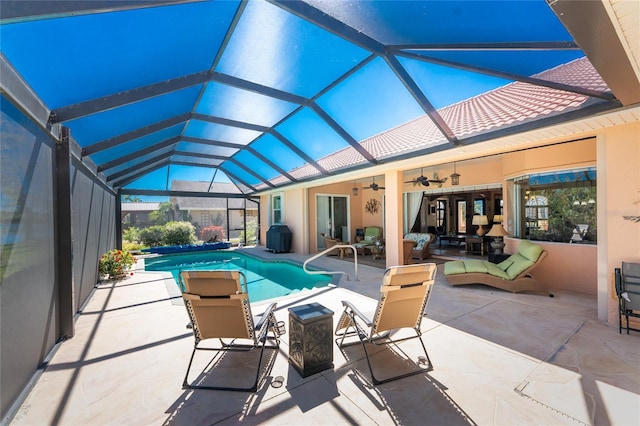 pool featuring a ceiling fan, glass enclosure, a patio area, and outdoor lounge area