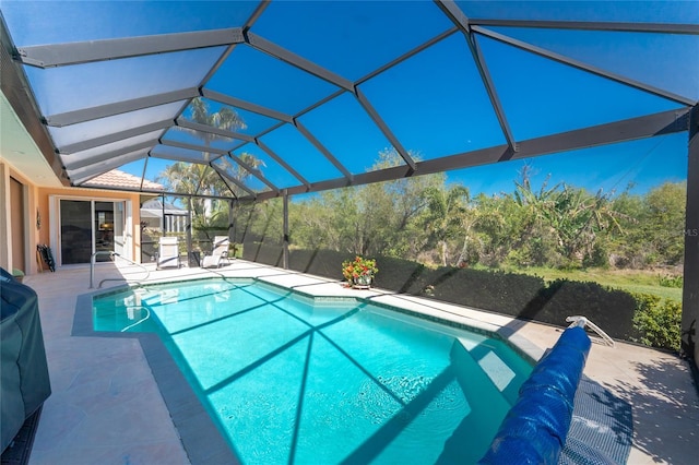 pool featuring glass enclosure and a patio