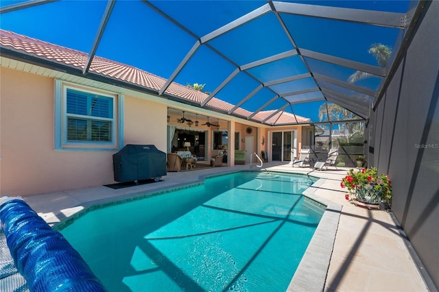 outdoor pool with a lanai, a grill, ceiling fan, and a patio area