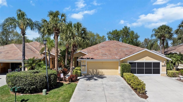 view of front facade featuring stucco siding, concrete driveway, an attached garage, and a tile roof