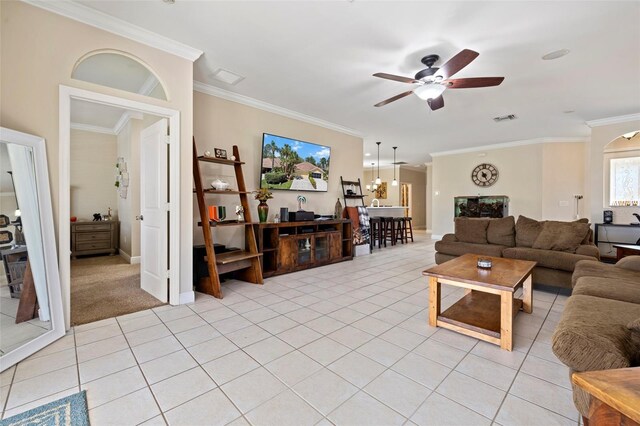 living area with crown molding, light tile patterned floors, and ceiling fan