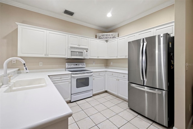 kitchen featuring visible vents, ornamental molding, light tile patterned floors, white appliances, and a sink