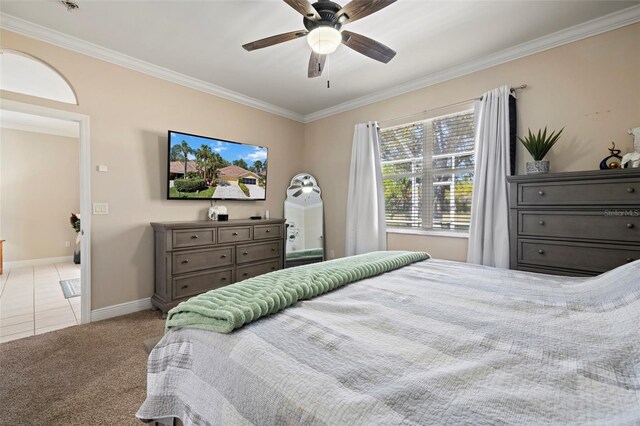 bedroom with a ceiling fan, baseboards, carpet, and crown molding