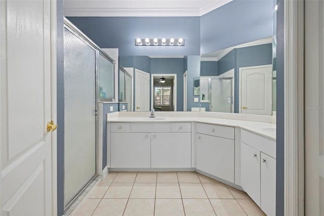 bathroom with tile patterned flooring, ornamental molding, double vanity, a stall shower, and a sink