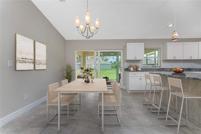 dining space with a chandelier, lofted ceiling, and baseboards