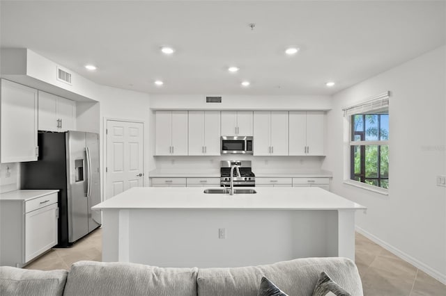 kitchen featuring visible vents, stainless steel appliances, light countertops, and a sink